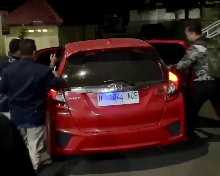 NGACIR: Korwil BGN Pamekasan saat dikawal masuk ke dalam mobil warna merah usai menjalani pemeriksaan intensif selama 6 jam di ruang penyidik Satreskrim Polres Pamekasan, Jum’at (5/6/2026).
